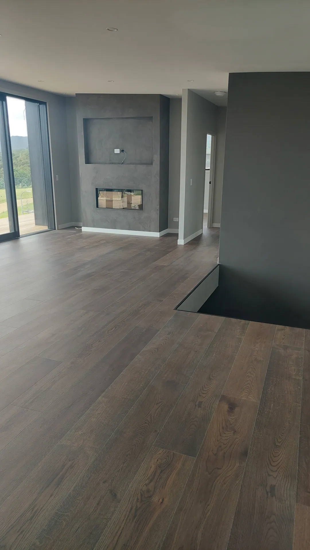 Dark oak floor by a fireplace.
