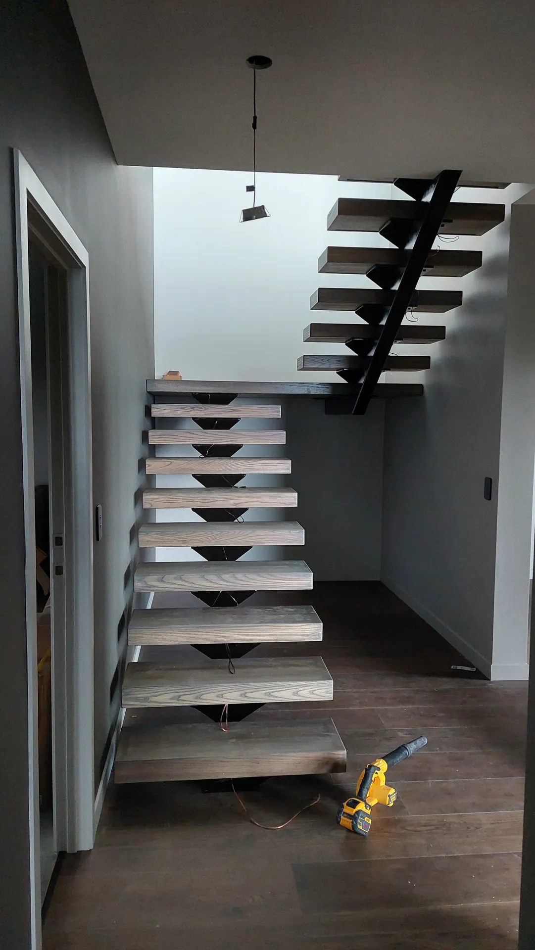 Floating timber treads on a black steel stringer.