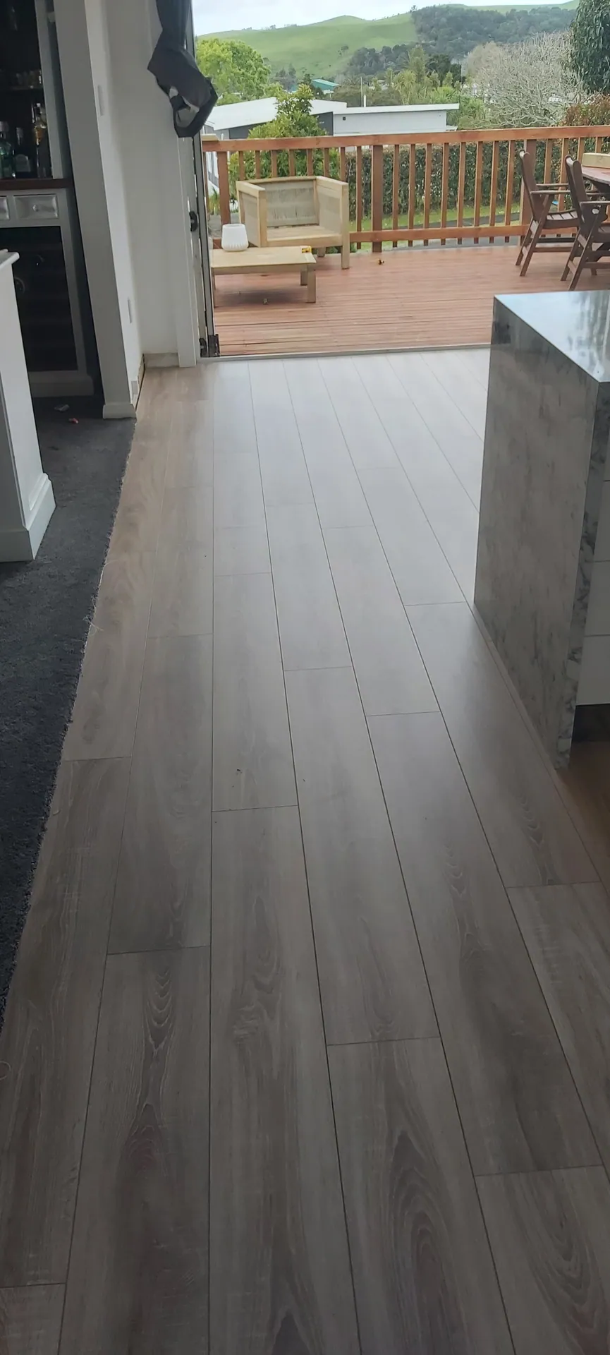 Grey-brown floor beside a kitchen island.