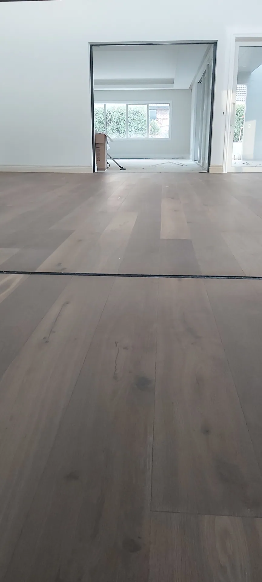 Grey-brown oak floor through to a lounge.