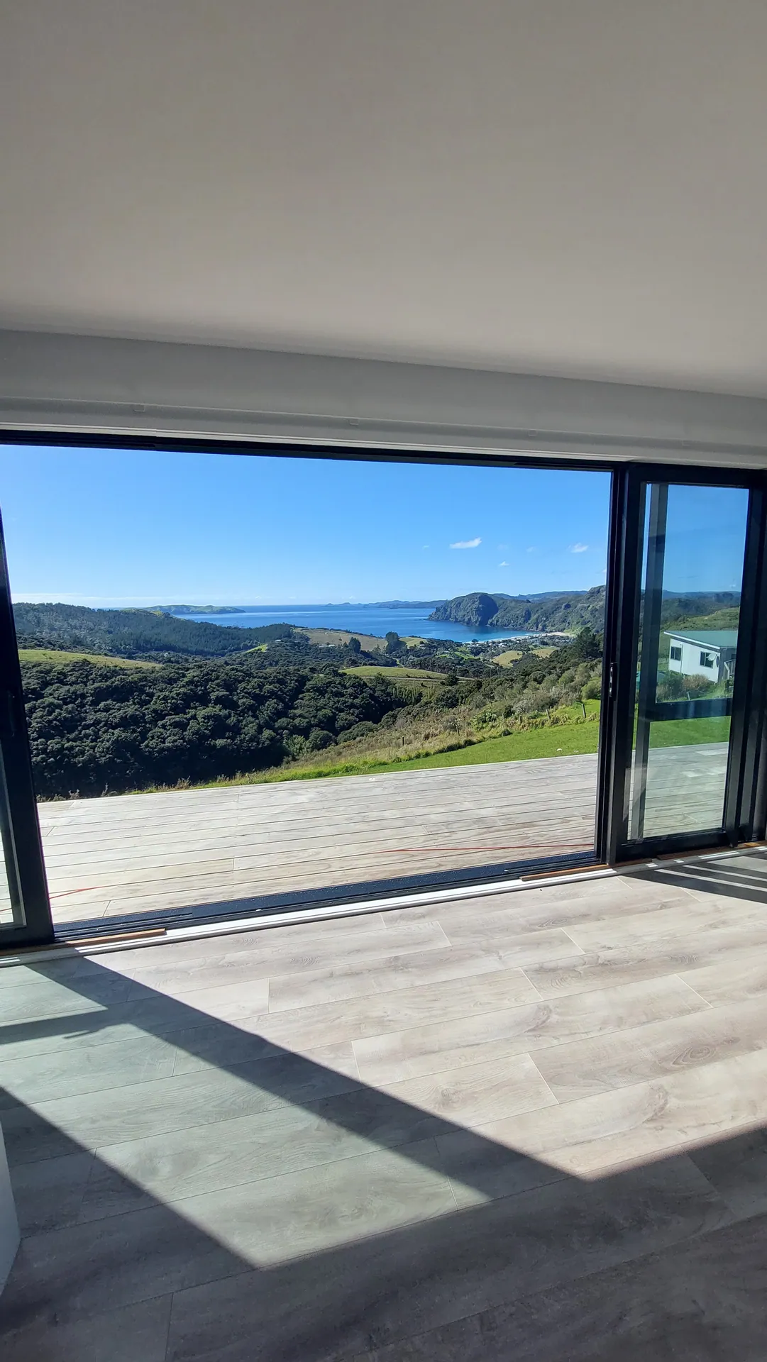 Grey floor by sliding doors with a bay view.