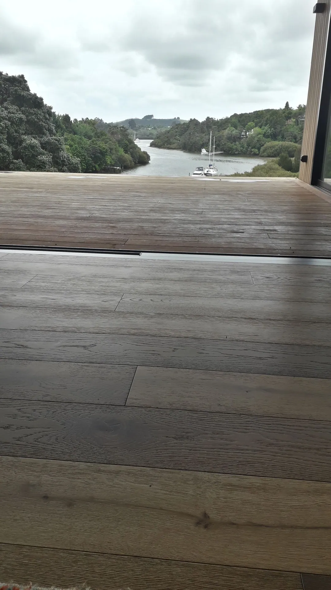 Grey timber floor out to a river view.