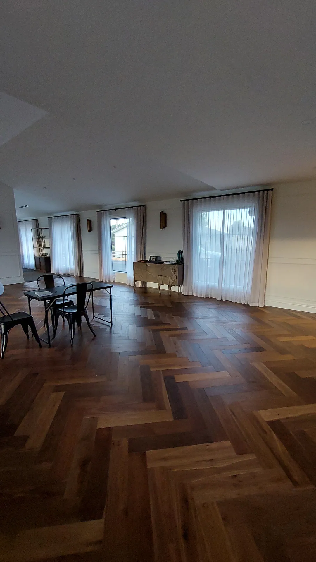 Herringbone oak through a long dining room.