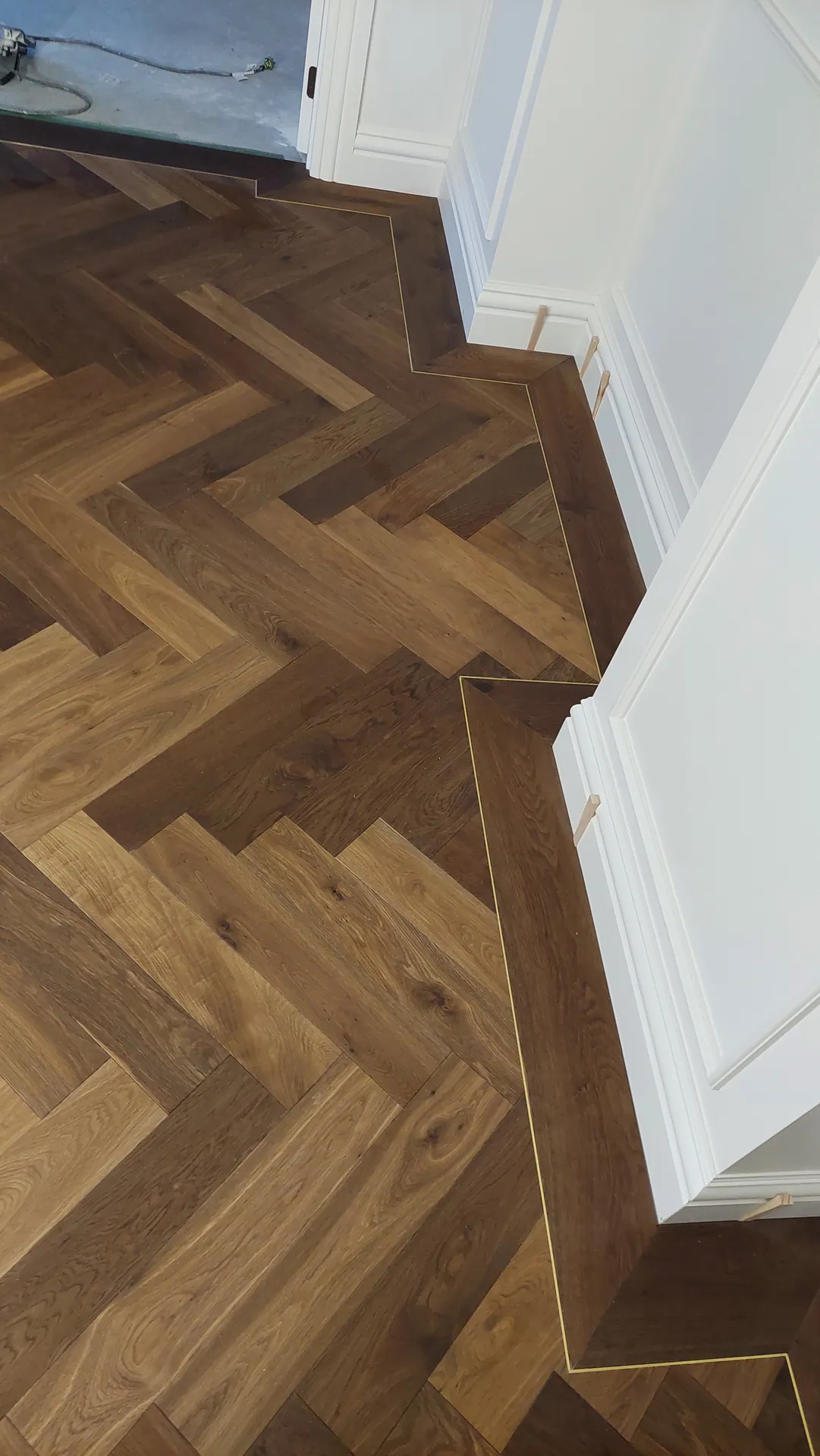 Herringbone with a mitred border at a corner.