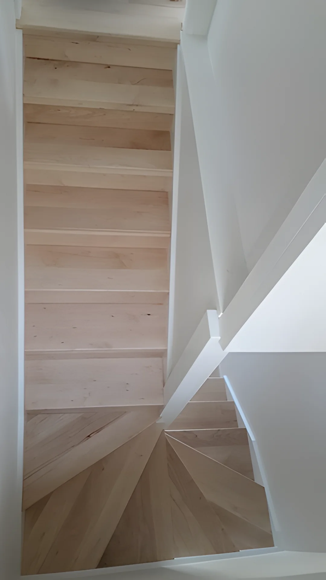 Pale timber winder stairs from above.