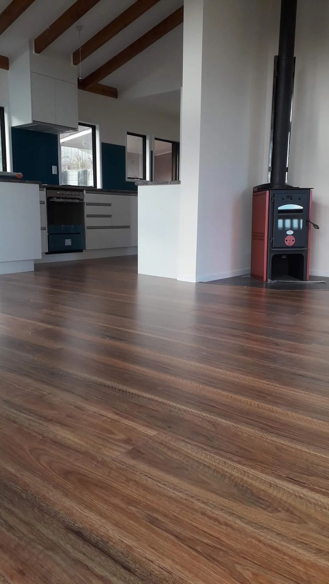Rich brown timber floor in an open-plan living room.
