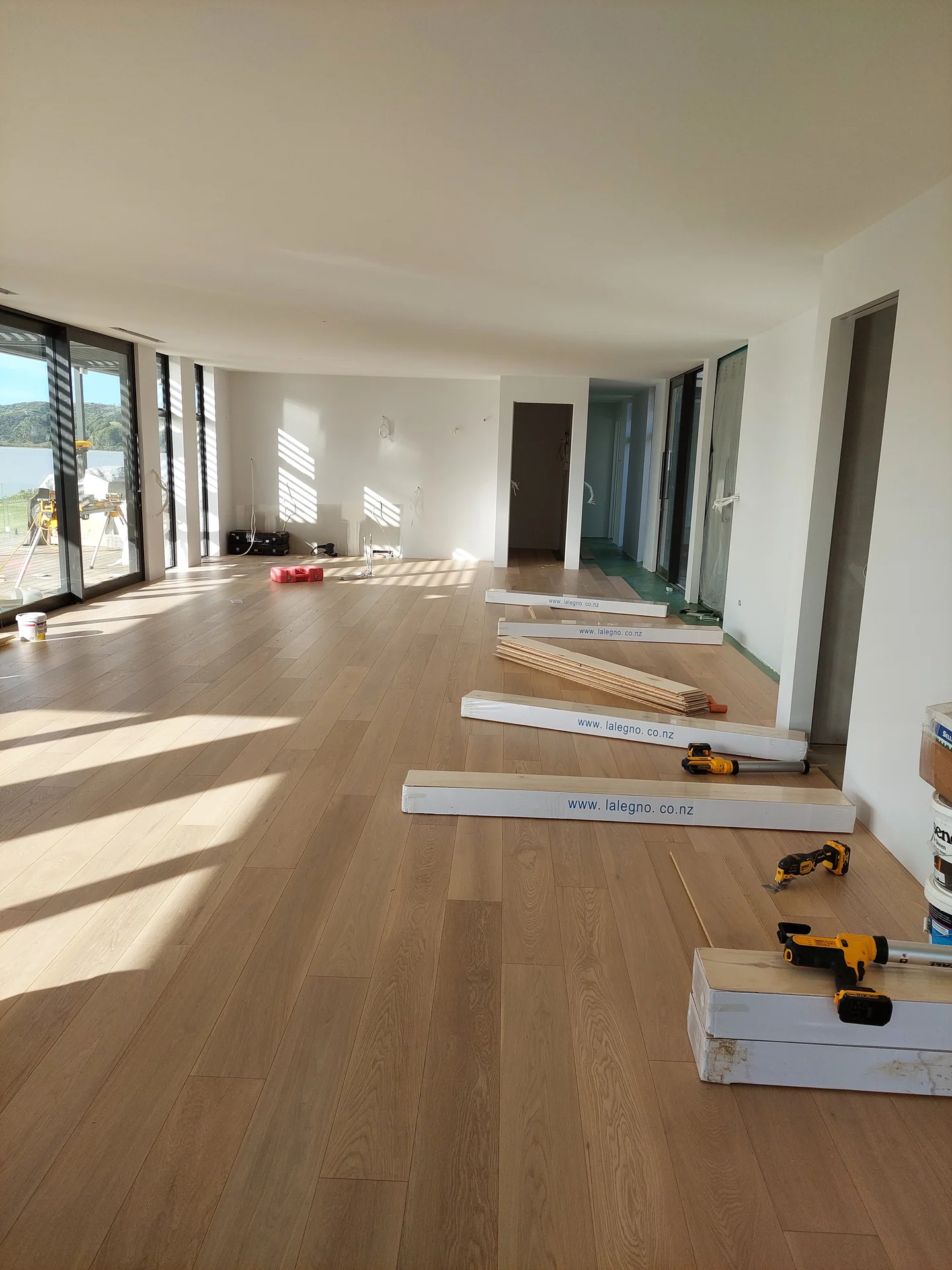 Oak floor going down in a long open room.