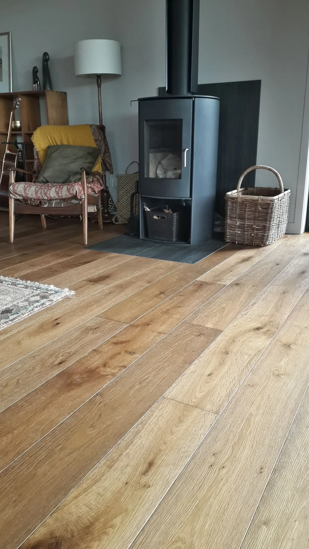 Wide oak floor by a wood burner.